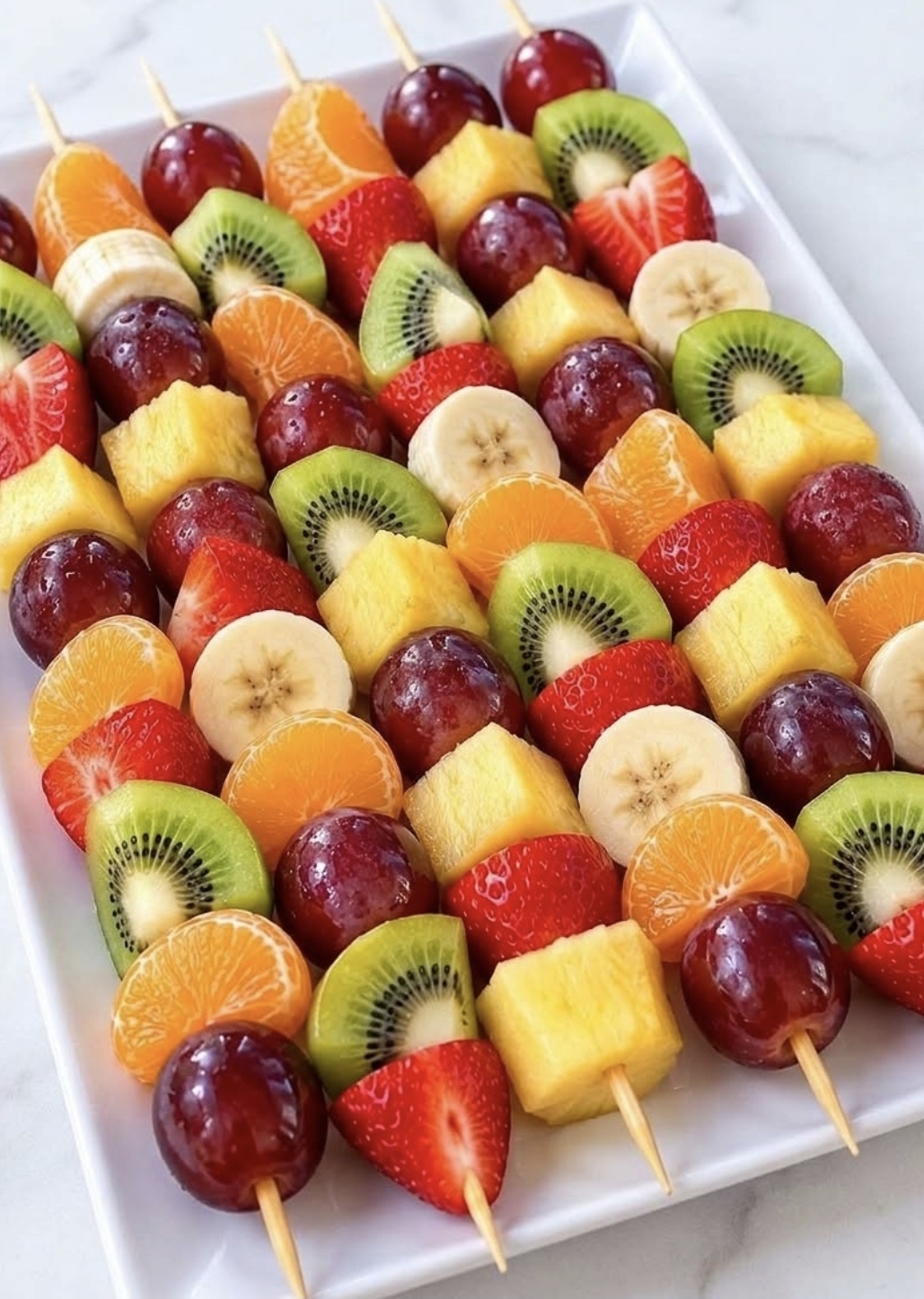 Fruit skewers with pineapple, grapes, kiwi, banana and strawberries